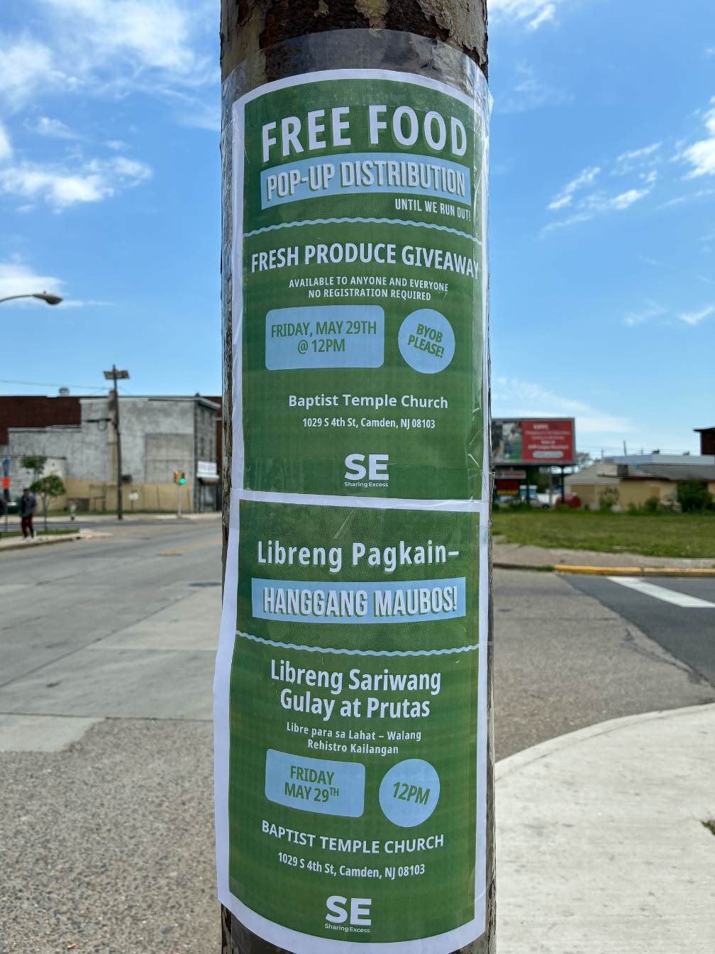 Close-up of bilingual Sharing Excess flyer on a bus stop pole
