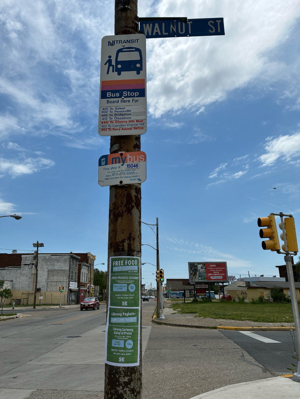 Bus stop on Walnut Street with multilingual Sharing Excess flyer